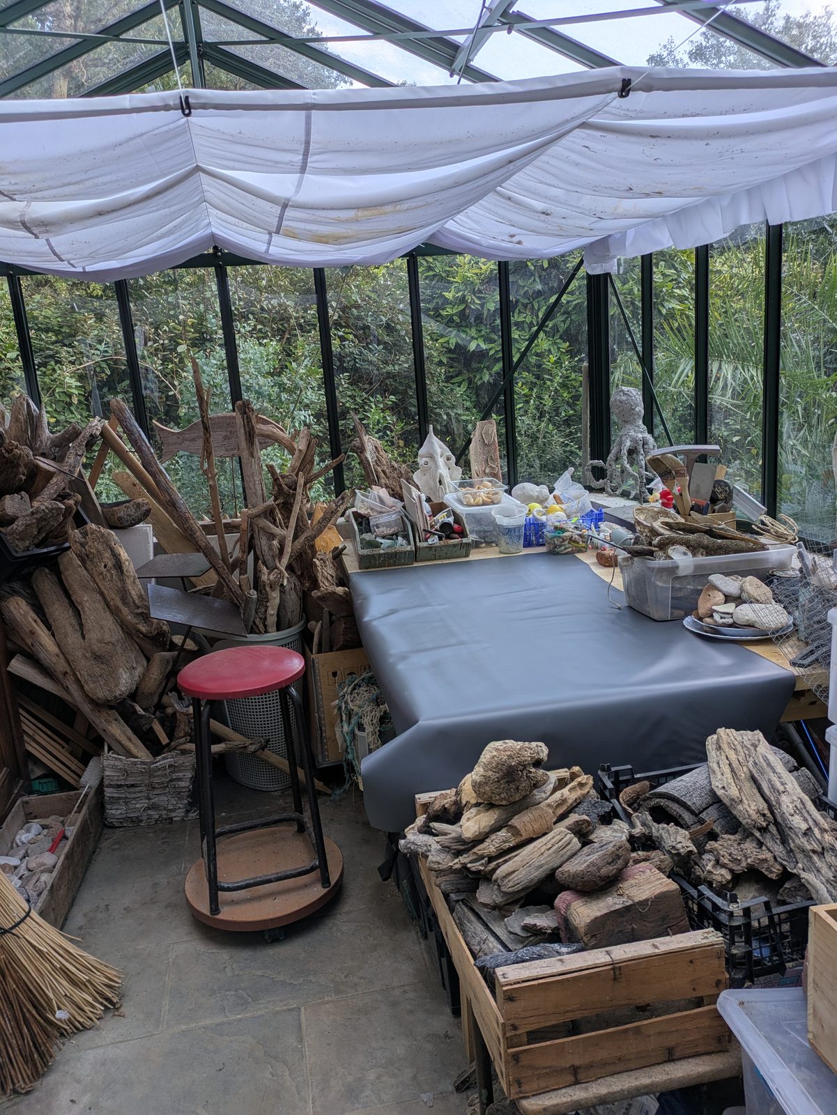 La serre-atelier de Catherine Evette, remplie de bois flottés et de matériaux glanés